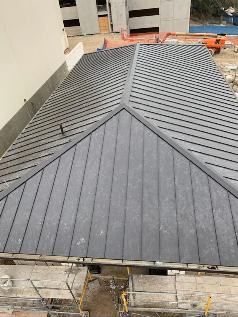 Commercial metal roof construction with crane equipment in Pike Road